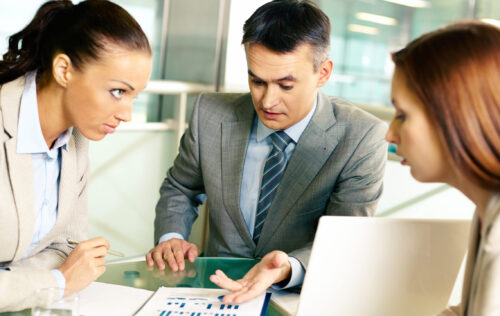 Group of business partners interacting at meeting in office